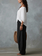Conjunto de top blanco con hombros al aire y pantalones acampanados estilo linterna